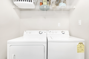 Two white dryers are in a laundry room at Paces Pointe Apartment Homes, Matthews